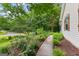 Exterior view of a home featuring a sidewalk and lush garden landscaping at 205 N Strathmore Dr, Sharpsburg, GA 30277