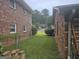 View of backyard between two brick buildings showcasing green grass and a chain link fence at 1110 Hilburn Se Dr, Atlanta, GA 30316