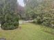 A lovely front yard with healthy green grass and mature trees lining the road at 1110 Hilburn Se Dr, Atlanta, GA 30316