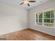 Spare bedroom with a large window with an outdoor view, hardwood floors, and ceiling fan at 55 Etheridge Rd, Temple, GA 30179