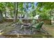 Backyard featuring a fire pit with chairs, beautiful plants, and grass at 15 Skipton Ct, Sharpsburg, GA 30277