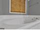 Inviting bathroom featuring a soaking tub with tile surround and neutral wall color at 15 Skipton Ct, Sharpsburg, GA 30277