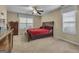 Cozy bedroom with neutral carpet, ceiling fan, and a comfortable bed with a red comforter at 15 Skipton Ct, Sharpsburg, GA 30277
