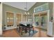 Bright dining area with multiple windows, chandelier, and adjacent glass-paneled door at 15 Skipton Ct, Sharpsburg, GA 30277