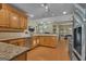 Kitchen featuring an island with wooden cabinetry, granite countertop with seating, stainless sink at 15 Skipton Ct, Sharpsburg, GA 30277