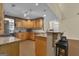 Well-lit kitchen with wooden cabinetry, granite countertops, and bar stool seating at 15 Skipton Ct, Sharpsburg, GA 30277
