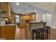 Charming kitchen features wooden cabinets, granite countertops, and a breakfast bar at 15 Skipton Ct, Sharpsburg, GA 30277