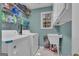 Functional laundry room with washer, dryer, sink, and ample storage shelving at 15 Skipton Ct, Sharpsburg, GA 30277