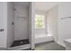 Modern bathroom with tiled shower, separate bathtub, and a window at 2576 Abbotts Glen Nw Dr, Acworth, GA 30101