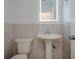 Updated powder bathroom features a pedestal sink, illuminated mirror, and a modern toilet at 2576 Abbotts Glen Nw Dr, Acworth, GA 30101