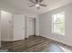 Bright bedroom features a ceiling fan, wood-look flooring, and a window with a view at 2576 Abbotts Glen Nw Dr, Acworth, GA 30101