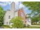 Two-story home featuring a brick chimney, and a large, grassy yard with mature trees at 2576 Abbotts Glen Nw Dr, Acworth, GA 30101