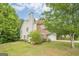 Two-story home featuring a brick chimney, and a large, grassy yard with mature trees at 2576 Abbotts Glen Nw Dr, Acworth, GA 30101