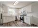 Well-lit kitchen with stainless steel appliances, white cabinets and hardwood floors at 2576 Abbotts Glen Nw Dr, Acworth, GA 30101