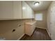 A laundry room with neutral colors, overhead storage, and a laminate floor at 1068 Longshore Dr, Decatur, GA 30032