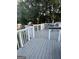 Wooden back deck with a gray stain and white railings, offering an outdoor space for relaxation at 517 Pebble Pt, Loganville, GA 30052