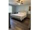 Serene bedroom with a neutral palette, a comfortable king-size bed, and wood-look flooring at 517 Pebble Pt, Loganville, GA 30052