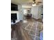 Open-concept living and dining area with wood floors, fireplace, and a modern ceiling fan at 517 Pebble Pt, Loganville, GA 30052