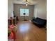 An open living space with wood floors, a ceiling fan, a window, and a futon at 517 Pebble Pt, Loganville, GA 30052