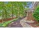 Backyard featuring tiered deck, stone walkway, and lush landscaping at 335 S Satinwood Pl, Roswell, GA 30076