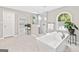 This primary bath features a soaking tub, glass enclosed shower, and light gray walls at 335 S Satinwood Pl, Roswell, GA 30076
