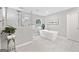 A modern bathroom featuring a soaking tub, tiled shower, and plenty of natural light at 335 S Satinwood Pl, Roswell, GA 30076