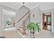Bright foyer featuring tile floors, wooden stairs, and views into adjacent dining and living areas at 335 S Satinwood Pl, Roswell, GA 30076