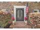 Elegant arched double doors framed by manicured plants and an American flag at 335 S Satinwood Pl, Roswell, GA 30076