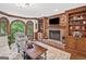 Comfortable living room featuring hardwood floors, a brick fireplace, built-in shelves, and a bay window at 335 S Satinwood Pl, Roswell, GA 30076