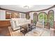 Cozy living room showcasing hardwood floors, a comfortable sofa, and a bay window overlooking the greenery at 335 S Satinwood Pl, Roswell, GA 30076