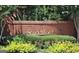 Community entrance sign with brick wall, shrubbery, and flowers that welcomes residents and visitors at 335 S Satinwood Pl, Roswell, GA 30076