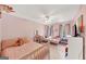 Comfortable bedroom with two twin beds, fan, and pink walls at 1625 Clark Lake Nw, Acworth, GA 30102