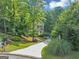 Charming home with a well-manicured lawn and long driveway surrounded by lush greenery at 1625 Clark Lake Nw, Acworth, GA 30102