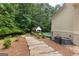 Stone pathway leading to a backyard featuring a gazebo and swimming pool, with air conditioning condensers on the right at 155 Carrolls Way, Fayetteville, GA 30215