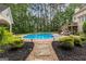 Backyard with a pool, stone walkway, and manicured landscaping leading to the house with an elevated deck at 155 Carrolls Way, Fayetteville, GA 30215