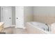 Bathroom features a soaking tub with tile surround and two doors at 155 Carrolls Way, Fayetteville, GA 30215