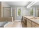Bright bathroom featuring double sink vanity, a soaking tub, and glass enclosed shower at 155 Carrolls Way, Fayetteville, GA 30215