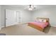 Spacious bedroom featuring neutral carpet, a ceiling fan, and open closet at 155 Carrolls Way, Fayetteville, GA 30215