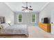 Bedroom features a ceiling fan, two windows, and a wooden dresser with a modern television at 155 Carrolls Way, Fayetteville, GA 30215