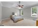 Bedroom features a ceiling fan and natural light from two windows overlooking a backyard at 155 Carrolls Way, Fayetteville, GA 30215