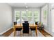 Light-filled dining room with a wooden table, black chairs, and large windows at 155 Carrolls Way, Fayetteville, GA 30215