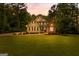 Charming two-story home at dusk featuring a manicured lawn and inviting curb appeal at 155 Carrolls Way, Fayetteville, GA 30215