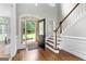 Bright foyer featuring hardwood floors, staircase, and doorway to landscaped outdoor space at 155 Carrolls Way, Fayetteville, GA 30215