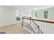 Bright hallway featuring a staircase with white railings and a bedroom view at 155 Carrolls Way, Fayetteville, GA 30215