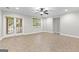 Neutral living room with tiled floor, ceiling fan, recessed lighting, and glass doors to backyard at 155 Carrolls Way, Fayetteville, GA 30215