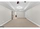 Large carpeted living room with tray ceiling, ceiling fan, recessed lighting, and access to other rooms at 155 Carrolls Way, Fayetteville, GA 30215