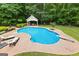 Aerial view of a backyard featuring an in-ground pool, a patio, lounge chairs, and a pool house at 155 Carrolls Way, Fayetteville, GA 30215