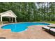 Backyard oasis featuring a large in-ground pool, a patio, a pool house, and mature trees at 155 Carrolls Way, Fayetteville, GA 30215