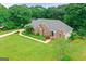Aerial view of a well-maintained brick home with a lush green lawn and mature trees at 344 Mckibben Dr, Locust Grove, GA 30248