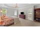 Main bedroom with tray ceilings, carpet flooring and a view of the attached bathroom at 344 Mckibben Dr, Locust Grove, GA 30248